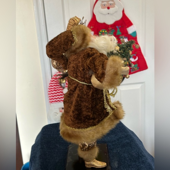 Golden velvet clad Santa holds greenery. - Picture 4 of 7